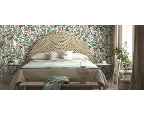 Slaapkamer met tweepersoonsbed, rotan hoofdeinde en bloemenbehang