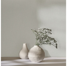 Close-up van een gestructureerd behang met twee decoratieve vazen en bloemstuk.