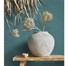 Decoratieve bloemenvaas met droogbloemen op een houten tafel voor een gestructureerde wand