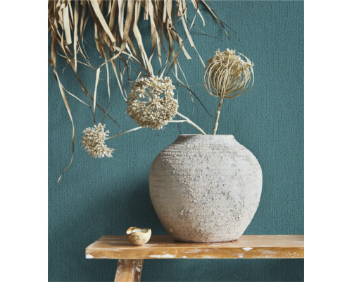 Decoratieve bloemenvaas met droogbloemen op een houten tafel voor een gestructureerde wand