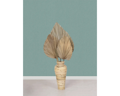 Decoratieve gedroogde palmbladeren in een rotan mand vaas op de vloer