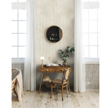 Lichte kamer met houten bureau, spiegel, rotan stoel en raam met gordijnen voor een gestructureerd behang.