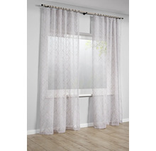 Transparant wit gordijn met verticaal golfpatroon voor een licht raam in een lichte en modern ingerichte kamer.