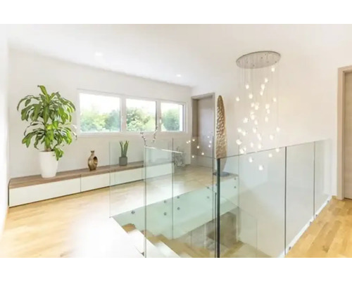 Lichte hal met trap, glazen balustrade, kamerplanten en hanglamp