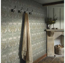 Gedetailleerde opname van een kamer met patroonbehang, kapstok, deken en open haard