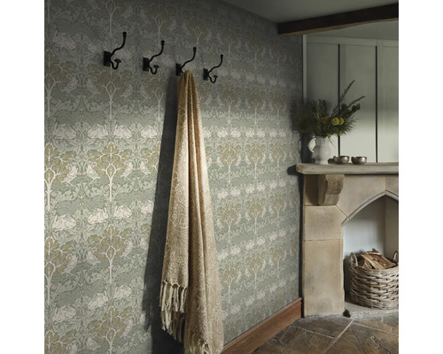 Gedetailleerde opname van een kamer met patroonbehang, kapstok, deken en open haard