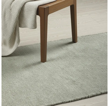 Tapijt in kamer met stoel en deken