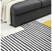 Detailweergave van bank en gestreept vloerkleed