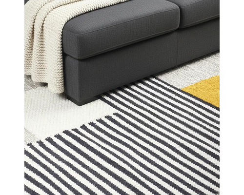 Detailweergave van bank en gestreept vloerkleed