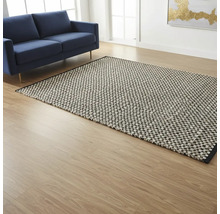 Woonkamer met blauwe bank en gemustert tapijt