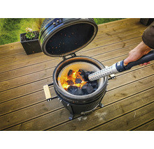 Keramische barbecue met gloeiende houtskool wordt aangestoken met een aanmaakblokjesstarter