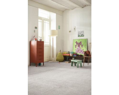 Lichte kinderkamer met commode, staande lamp en tapijt