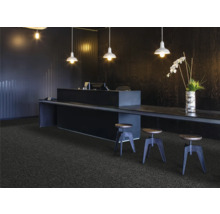 Receptieruimte met tapijt, bureau en barkrukken onder hanglampen