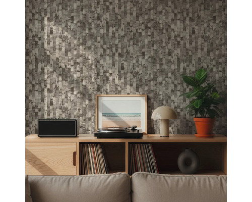 Woonkamer met patroonbehang, platenspeler, luidspreker, kamerplant en decoraties op een houten plank.