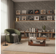 Woonkamer met fauteuil, salontafel en boekenkast onder platen