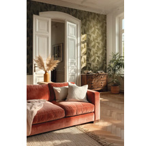 Woonkamer met rode bank, houten vloer en patroonbehang