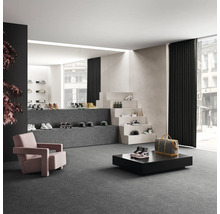 Ruime winkelruimte met schoenen, fauteuils en decoratieve trap