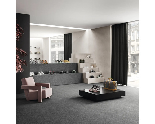 Ruime winkelruimte met schoenen, fauteuils en decoratieve trap