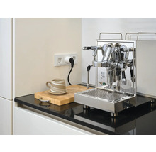 Roestvrijstalen espressomachine op aanrecht met kop en snijplank