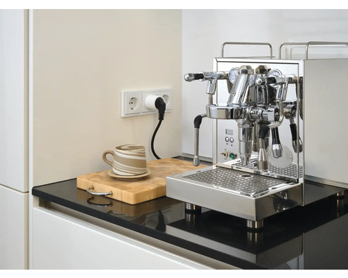 Roestvrijstalen espressomachine op aanrecht met kop en snijplank