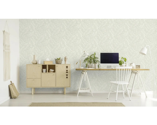 Een kamer met een behang met patroon, een bureau, een stoel en een kast