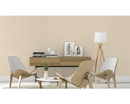 Woonkamer met houten fauteuils, dressoir en staande lamp voor een lichte en uitnodigende sfeer.