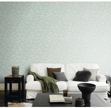 Woonkamer met witte bank en muur met bladerbehang