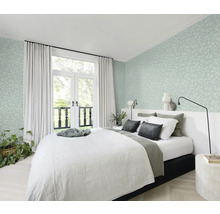 Slaapkamer met bed, gordijnen en bloemenbehang