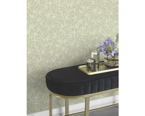 Behang met bladmotief achter bank met decoratie