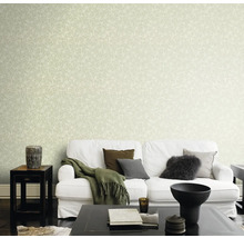 Woonkamer met witte bank voor muur met bladerbehang