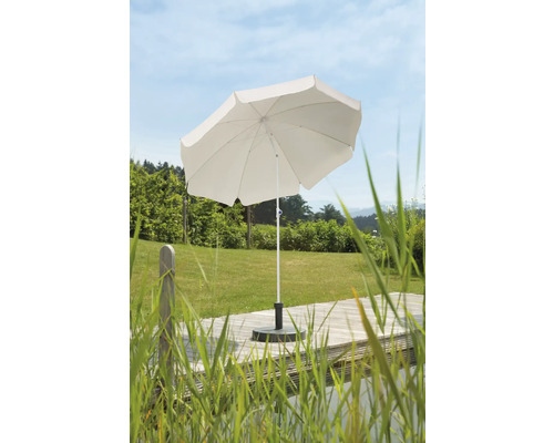 Witte parasol met parasolvoet op een houten terras in de tuin
