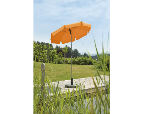 Oranje parasol op een houten terras in de tuin
