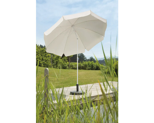 Witte parasol op een houten terras met gras op de achtergrond.