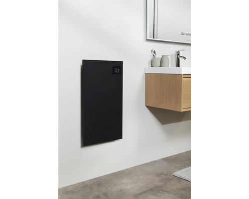 Badkamer met een zwart verwarmingspaneel aan de muur naast een wastafel