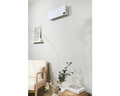 Wandgemonteerde airconditioner in een heldere woonkamer met fauteuil en decoratie