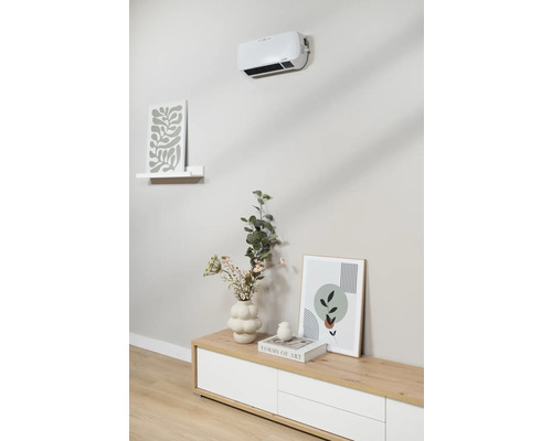 Aan de muur gemonteerde kachel boven dressoir met decoratie en schilderijen.