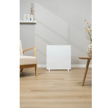 Witte radiator in woonkamer met fauteuil en tafel