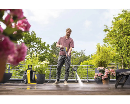 Man reinigt terras met Kärcher hogedrukreiniger.