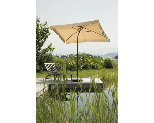 Tuinscene met parasol en ligstoel op houten terras aan de vijver