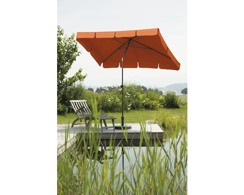 Rechthoekige parasol naast houten steiger met ligstoel in tuin