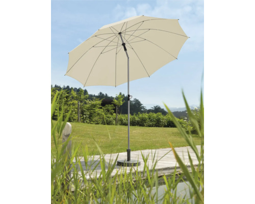 Geopende tuimelparasol op een terras met gazon op de achtergrond