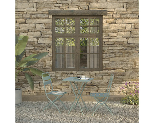 Tuinscene met bistrotafel en twee stoelen voor een stenen muur