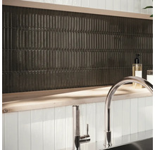 Wanddecoratie met langwerpige, donkere tegels en kraan