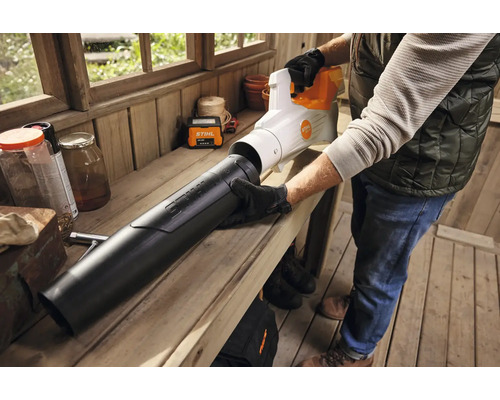 Een persoon monteert een Stihl bladblazer op een werkbank.