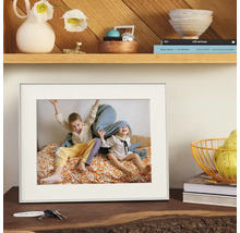 Witte fotolijst met passe-partout, geplaatst op een houten dressoir met decoratie.