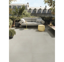 Terras met grijze vloertegels, zitplaatsen en planten