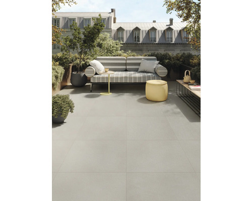 Terras met grijze vloertegels, zitplaatsen en planten