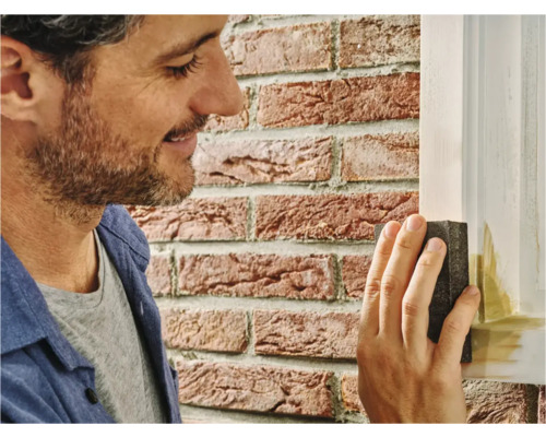 Man schuurt houten frame met schuurblok