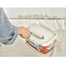 Verf wordt met een verfroller uit een verfemmer opgenomen.