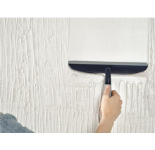 Hand die gips gladstrijkt met een gladstrijkspatel op een muur